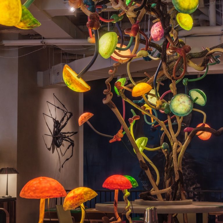 Manuela restaurant interior by night with artwork illuminated by a chandelier created by Mika Rottenberg