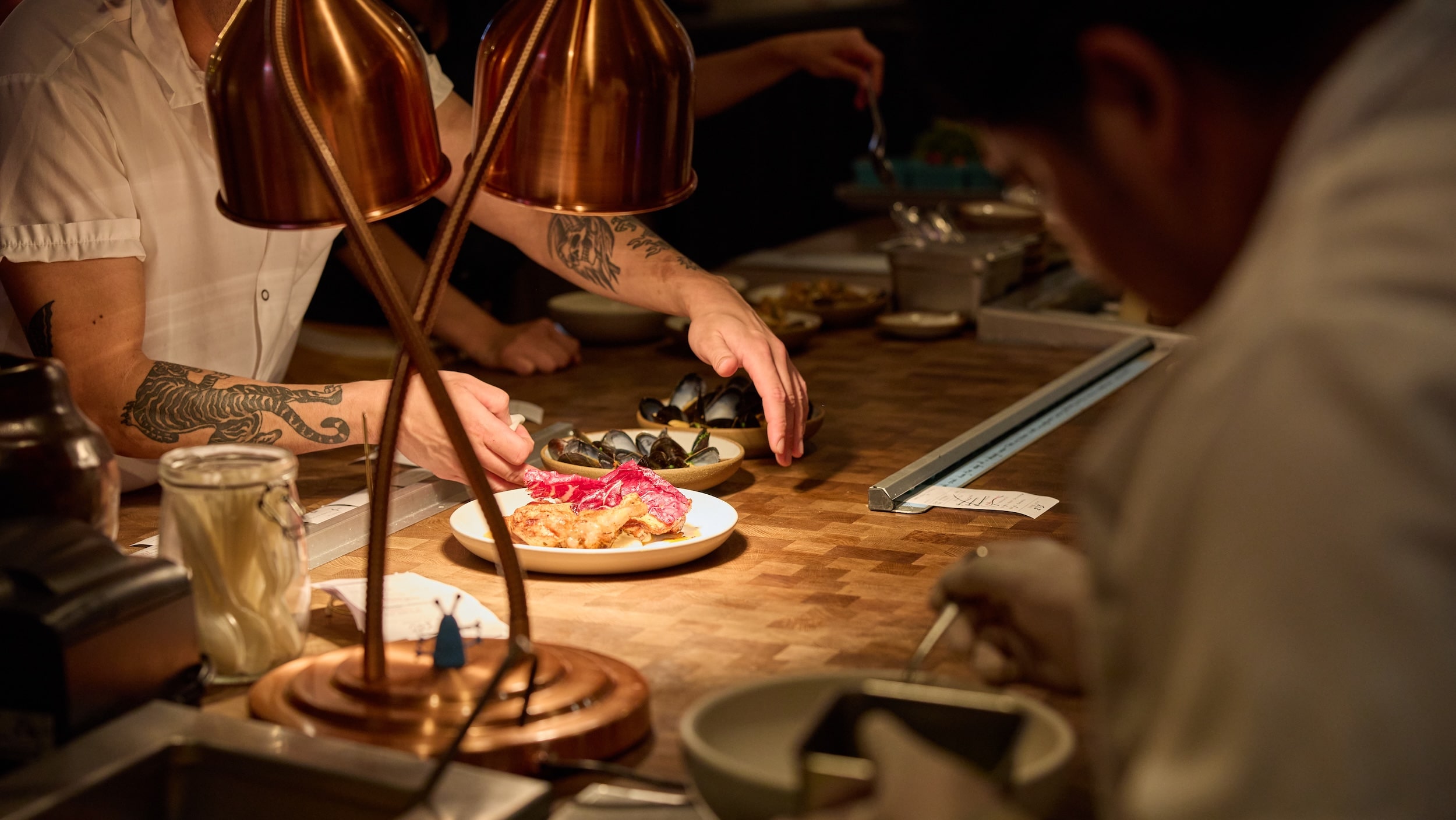 Chef plating a dish at the pass