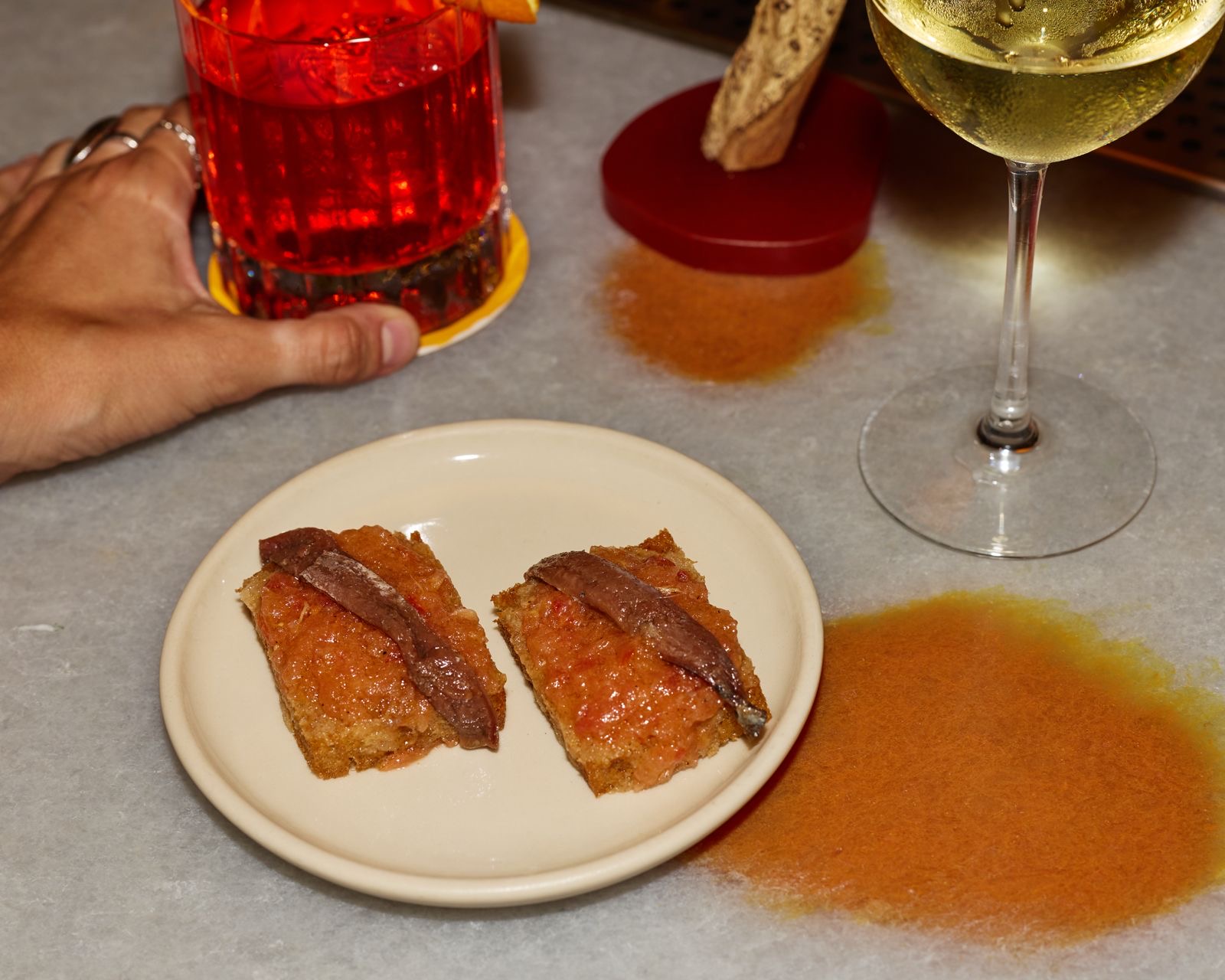 Anchovy toast on the bar with Happy Hour cocktails