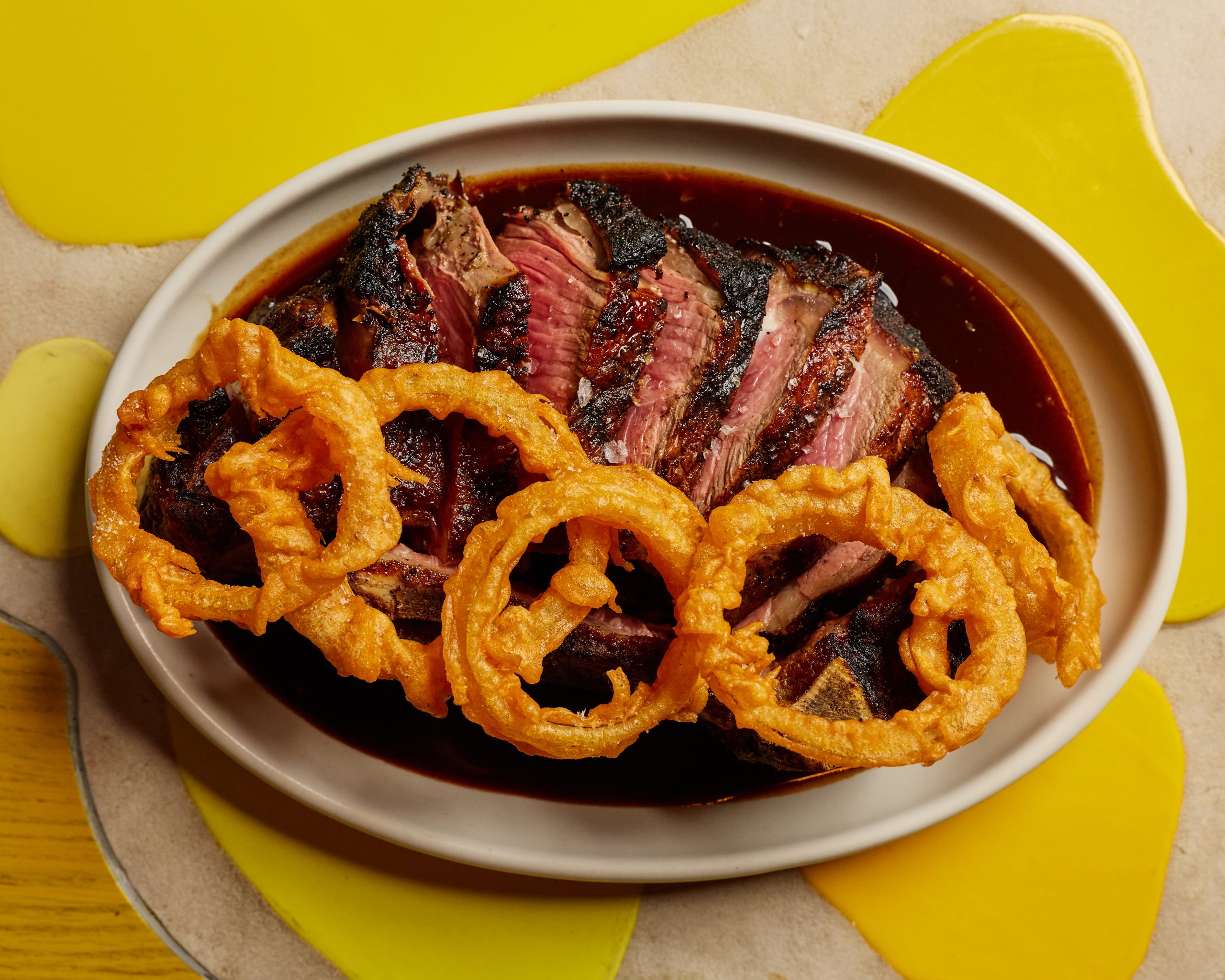30oz dry-aged bone in New York strip with bordelaise and onion rings
