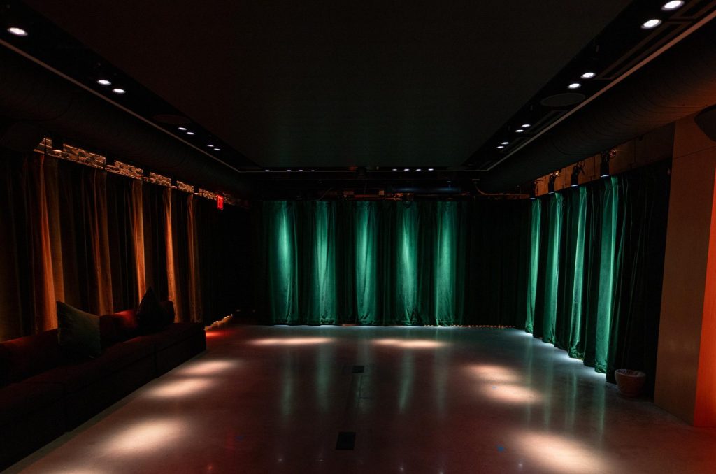 A dark room illuminated with warm red, blue and white lights.