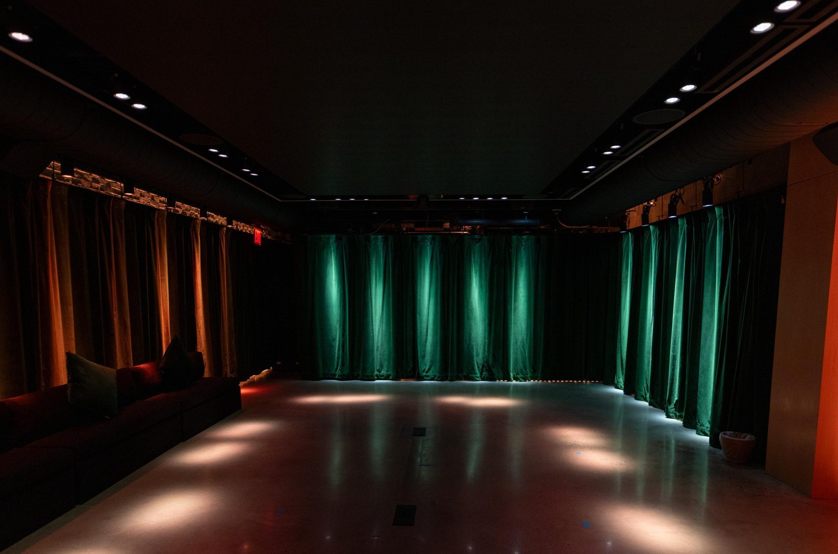 A dark room illuminated with warm red, blue and white lights.