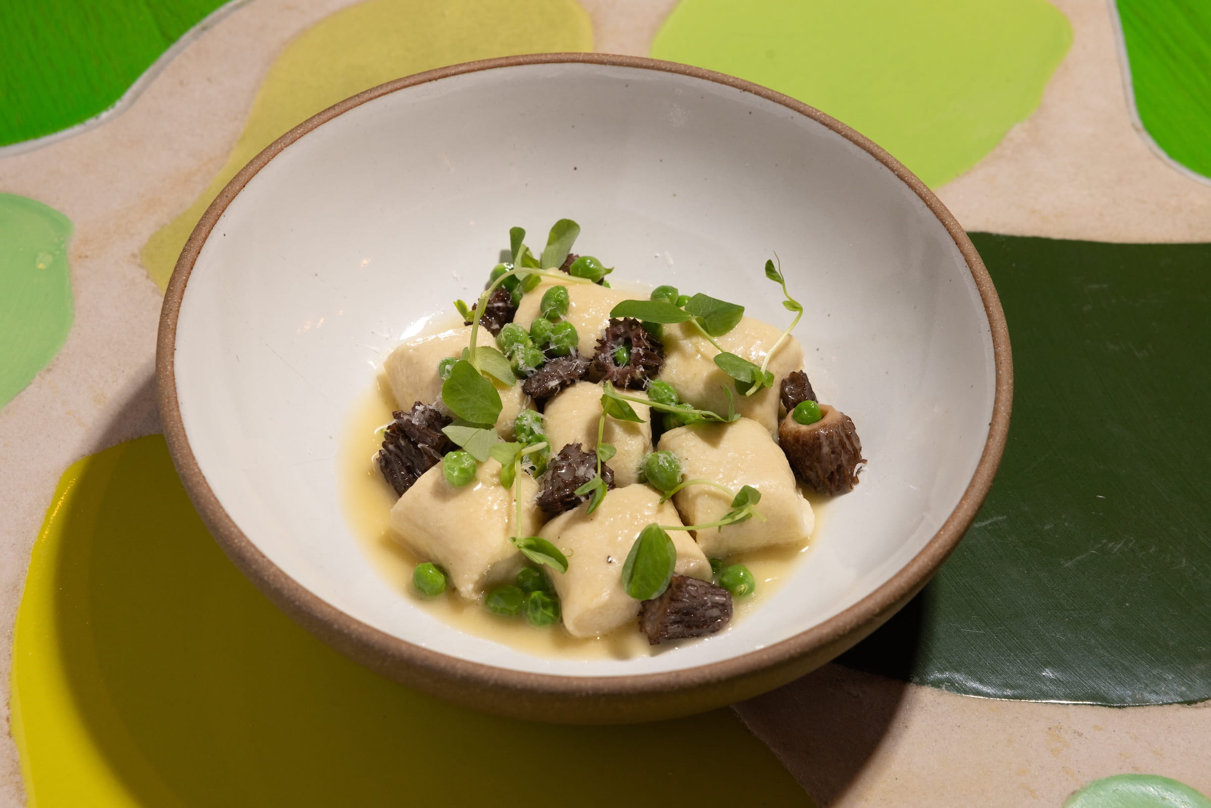 A plate of gnocchi with morels and peas