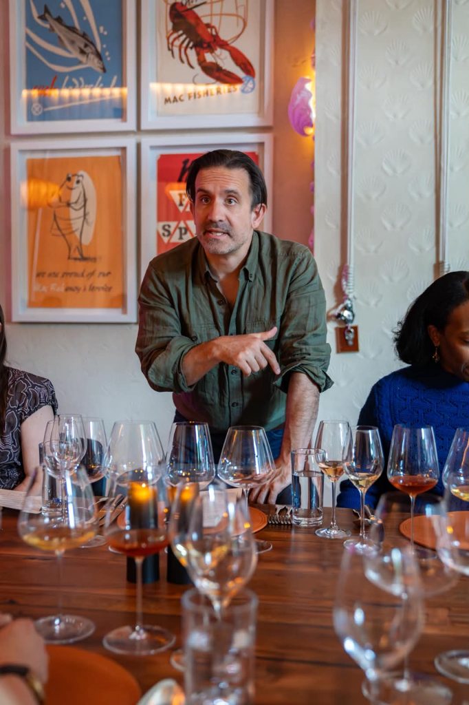 A portrait of Artfarm Wine Director Michael Scaffidi in front of wine glasses on a table
