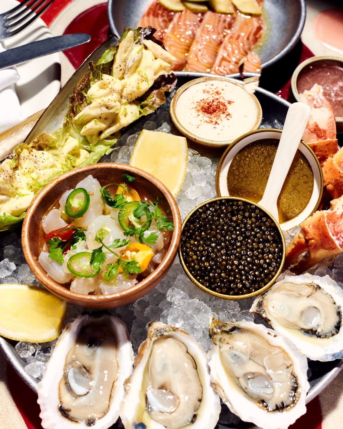 Seafood platter served on crushed ice with oysters, shellfish, sauces and lemon wedges